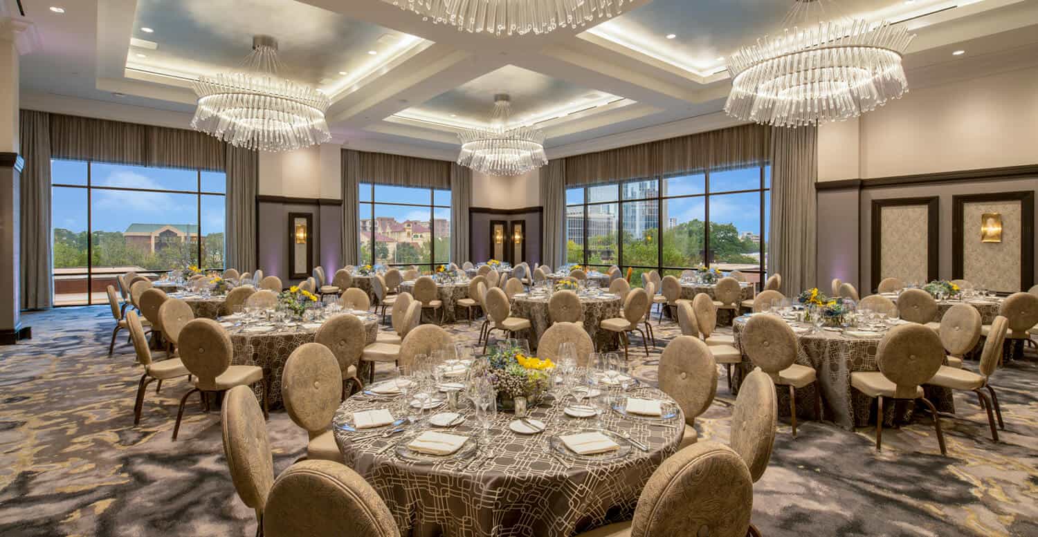 Ball room with round tables, set with dining places.