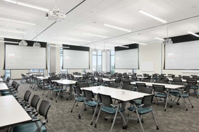 Large meeting room with multiple projector screens.