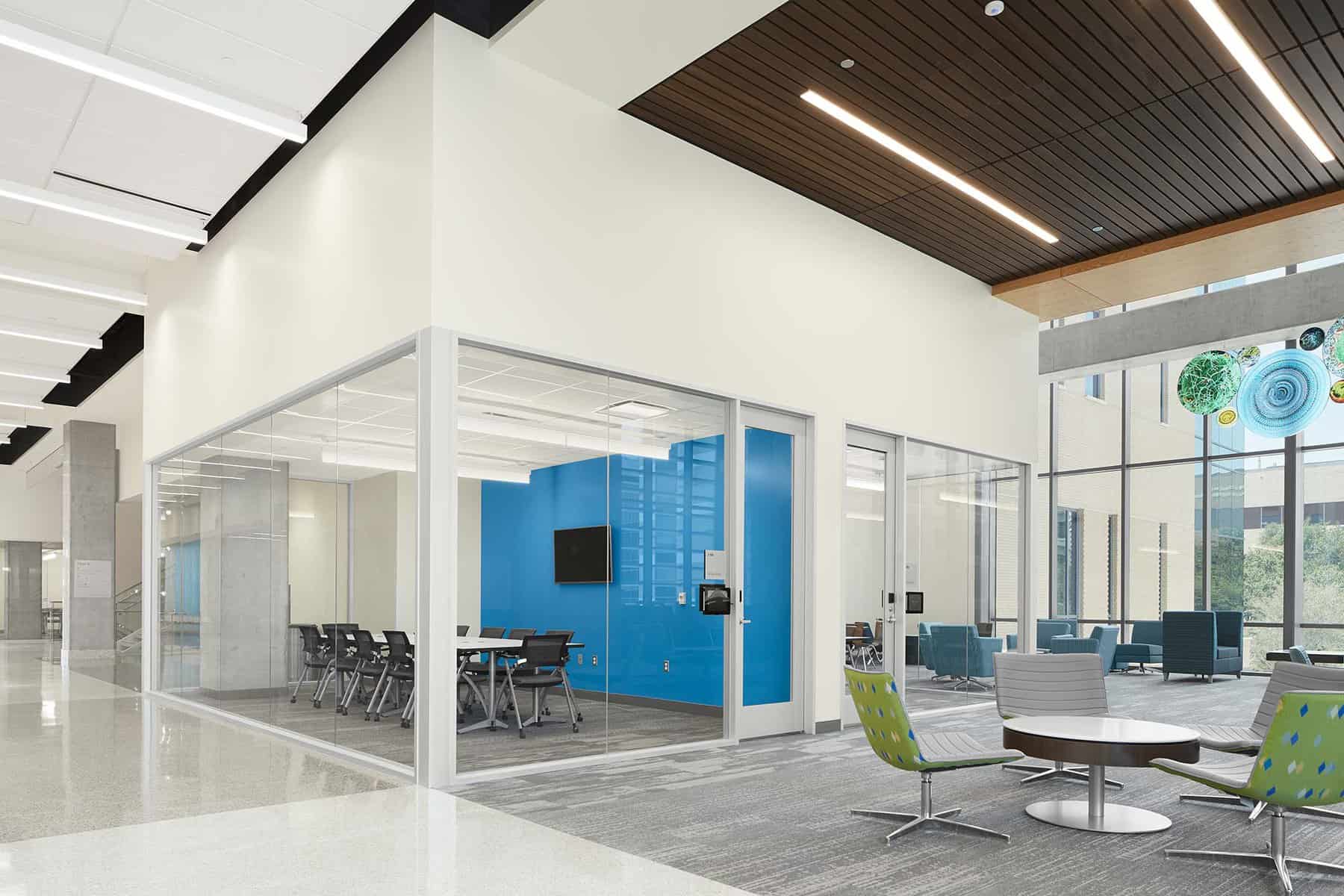 Meeting room with glass walls in the lobby of a learning center.