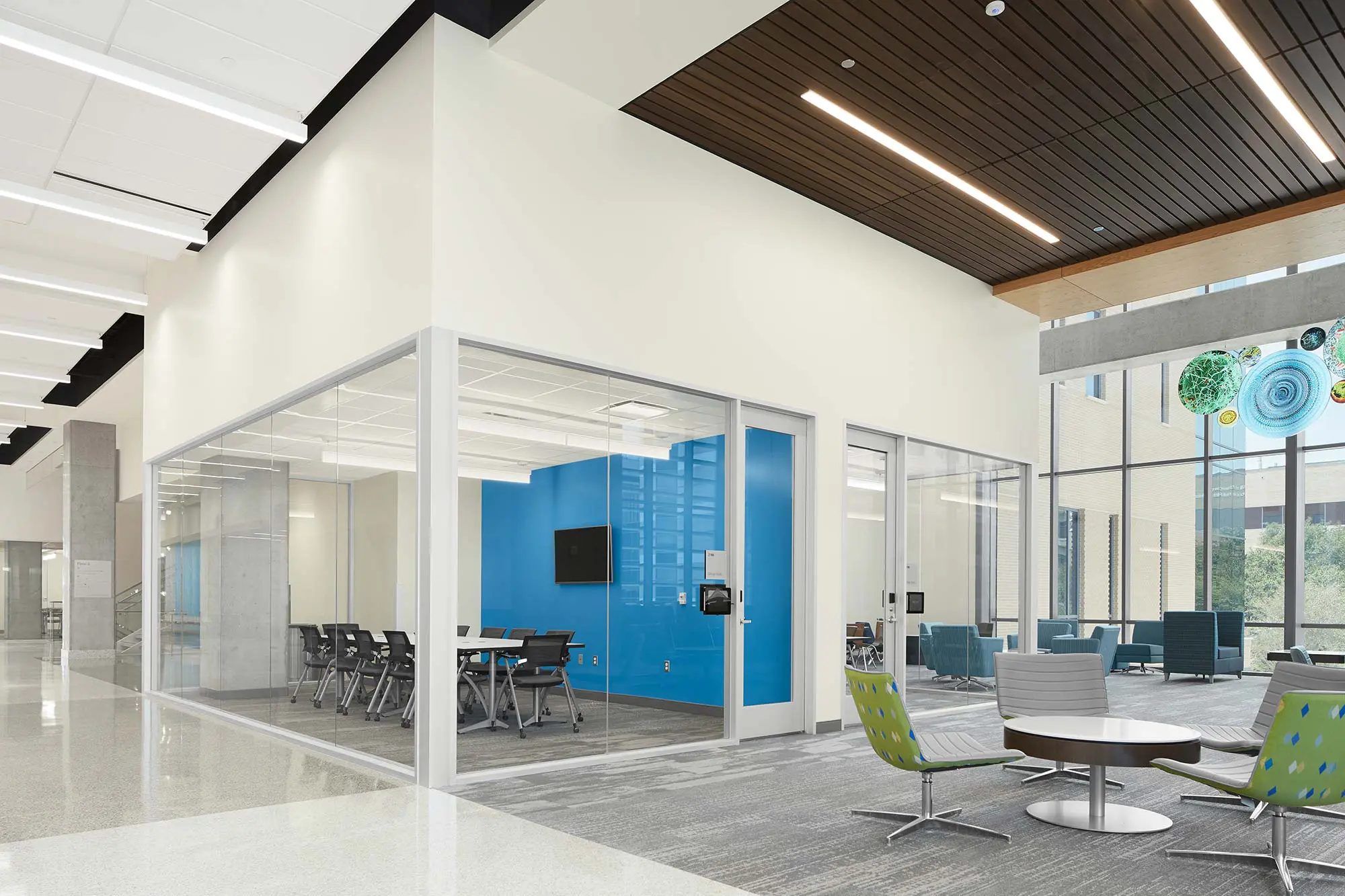 Meeting room with glass walls in the lobby of a learning center.