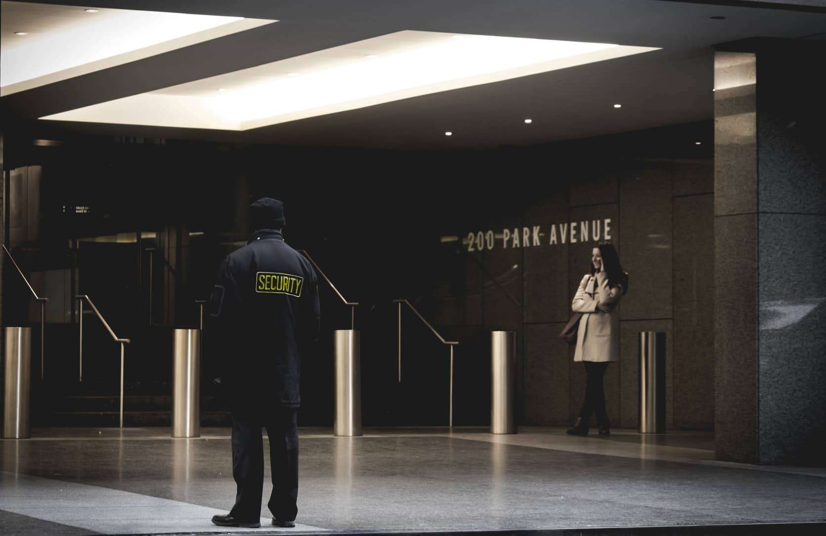 Security guard standing outside of a large office building