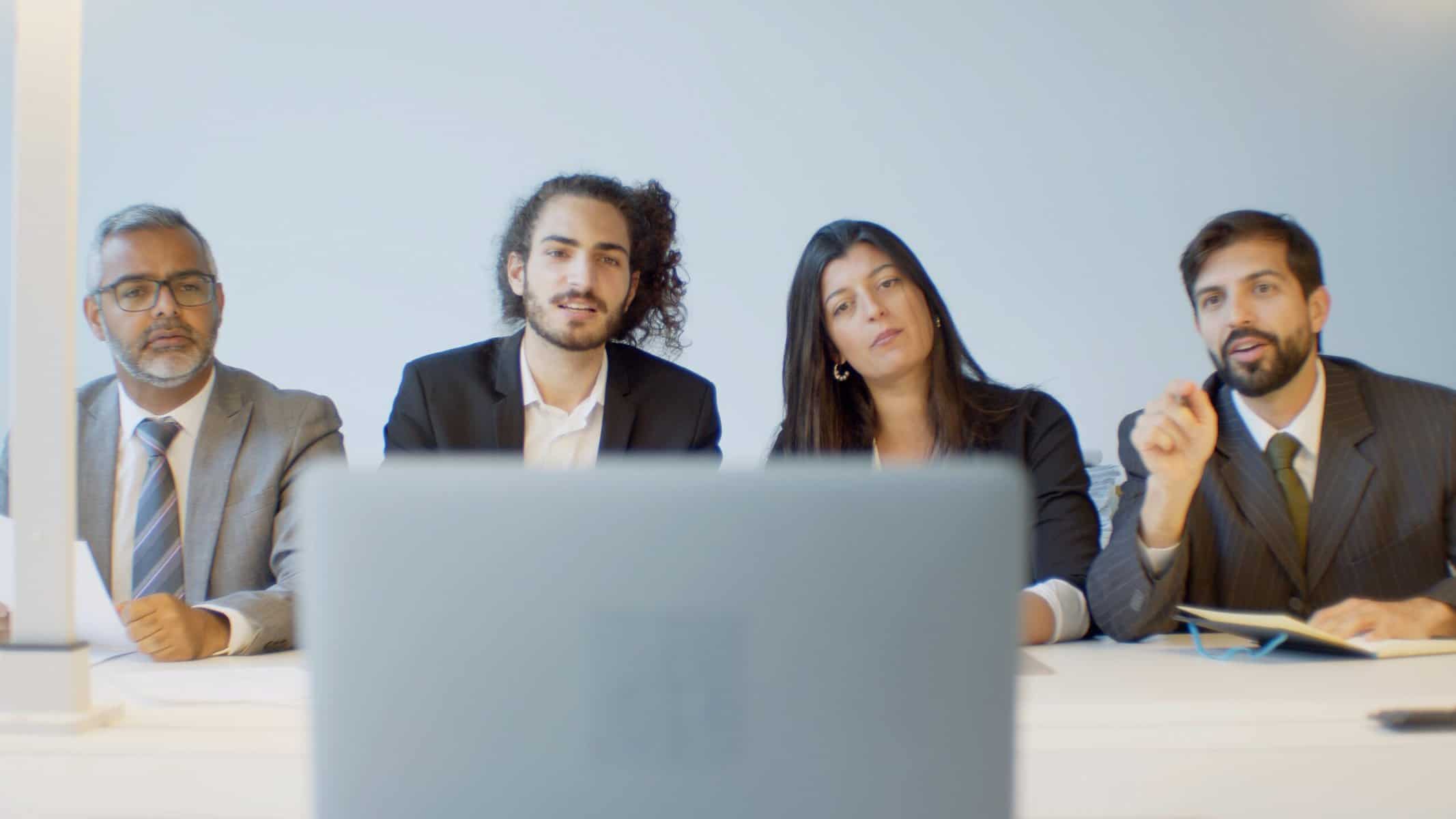 employees using a single laptop for a video conference